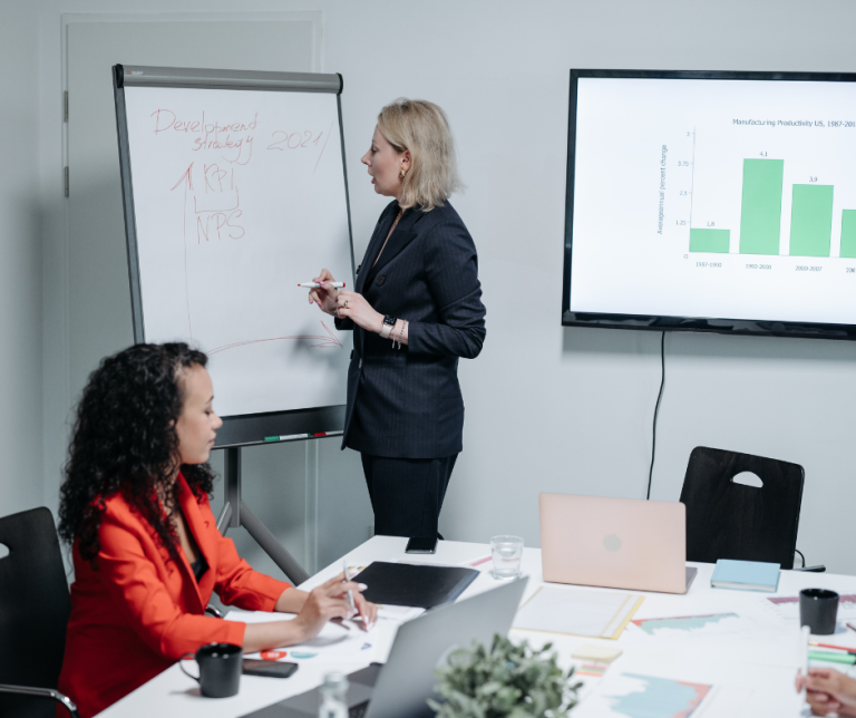 Coach and franchisee analyzing business growth metrics on a scorecard